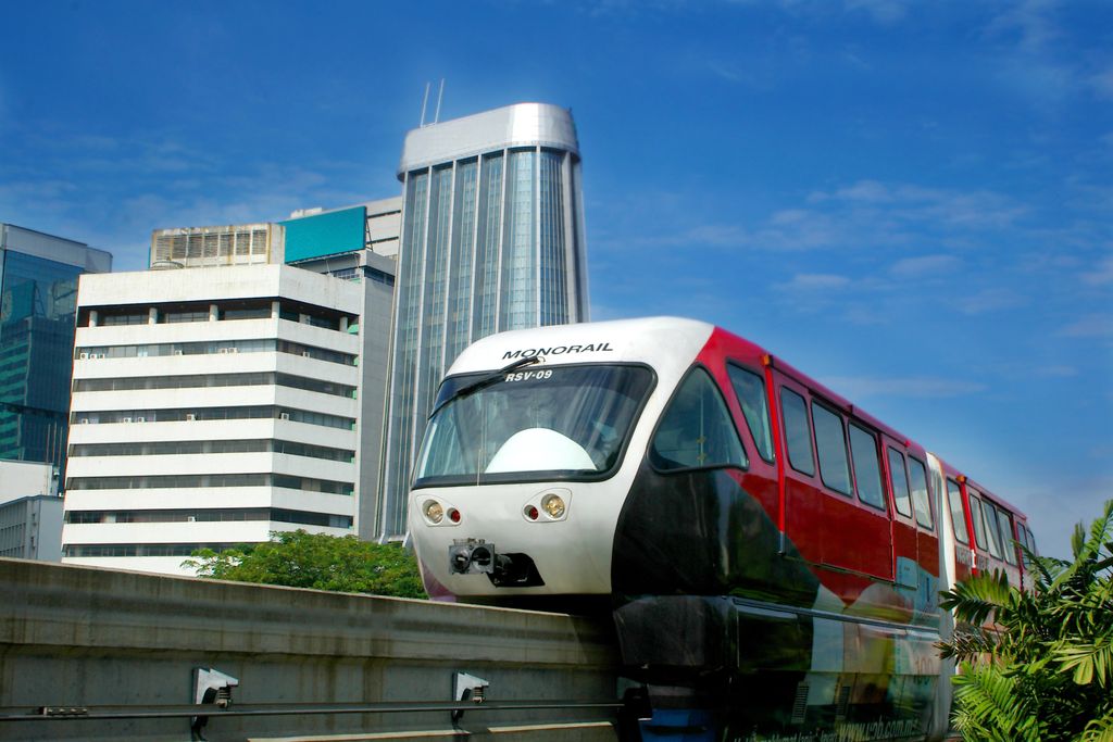 A monorail in Kuala Lumpur, Malaysia running with buildings in the background.